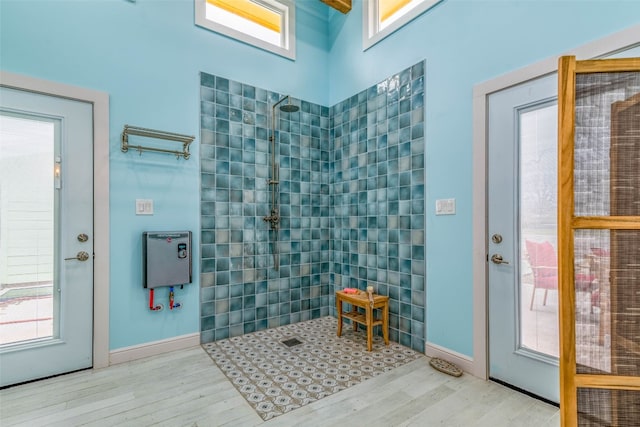 bathroom featuring tiled shower and wood-type flooring