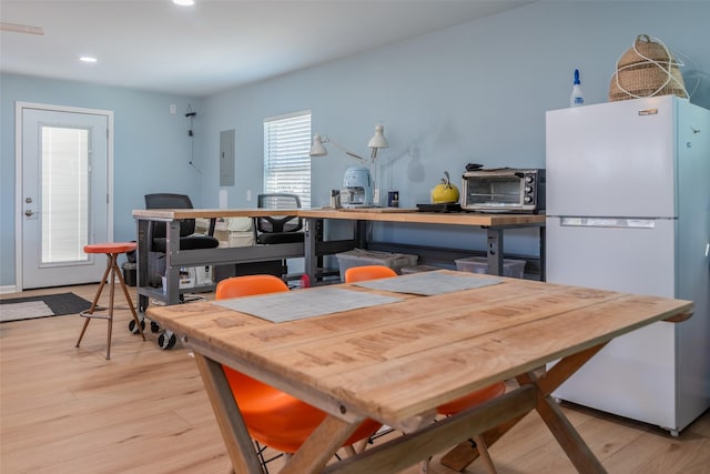 dining space featuring electric panel and light hardwood / wood-style floors