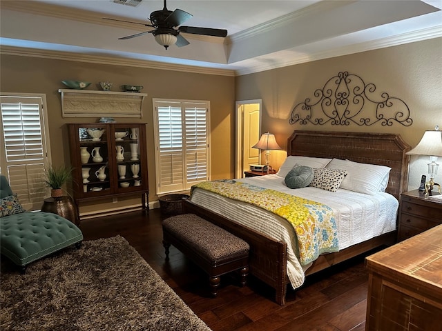 bedroom featuring ceiling fan, crown molding, a raised ceiling, and dark hardwood / wood-style floors