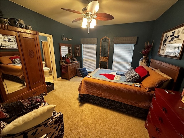 carpeted bedroom featuring ceiling fan and ensuite bath