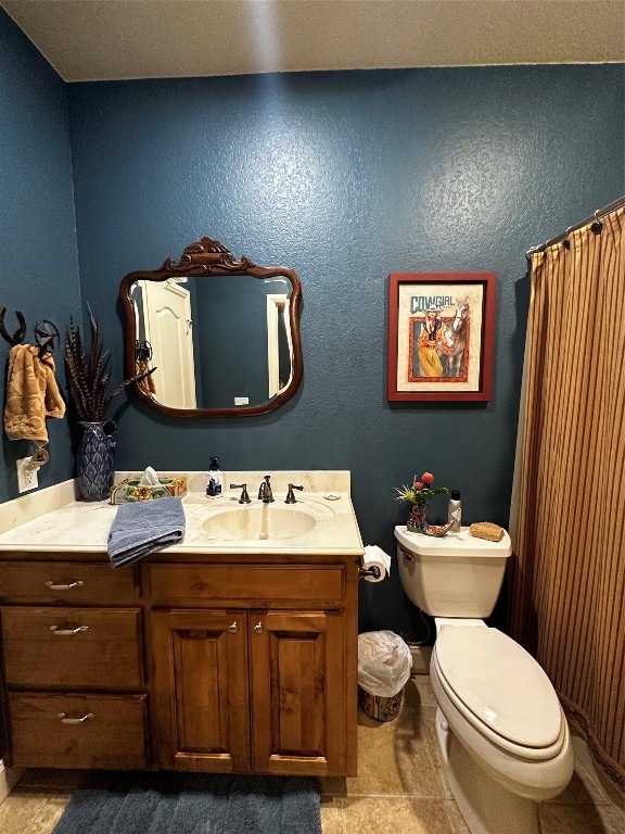 bathroom with vanity, tile floors, and toilet