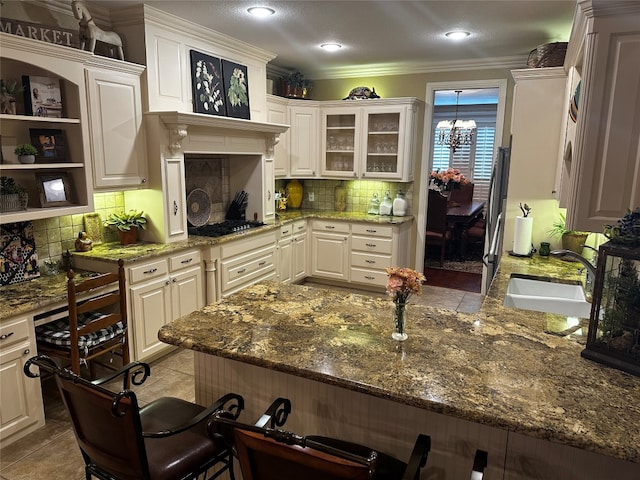 kitchen featuring stone counters, sink, light tile floors, tasteful backsplash, and crown molding