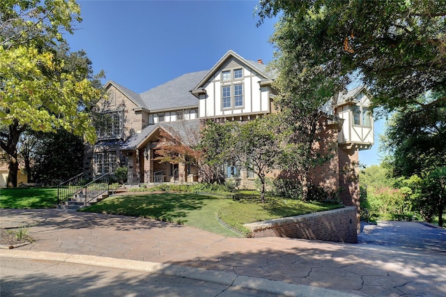 english style home featuring a front yard