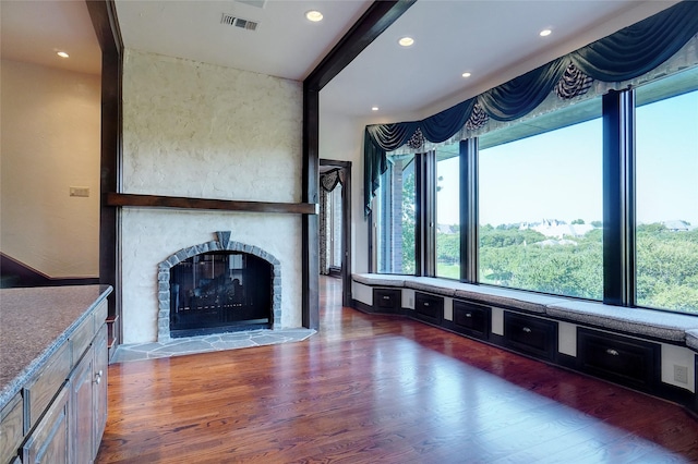 unfurnished living room featuring beamed ceiling, a multi sided fireplace, and dark hardwood / wood-style floors