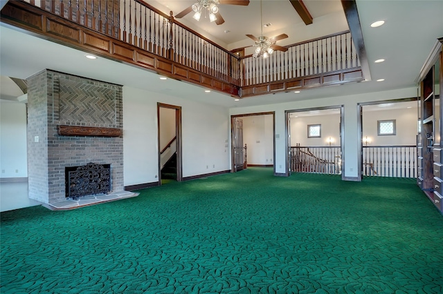 unfurnished living room featuring carpet, a towering ceiling, and a brick fireplace