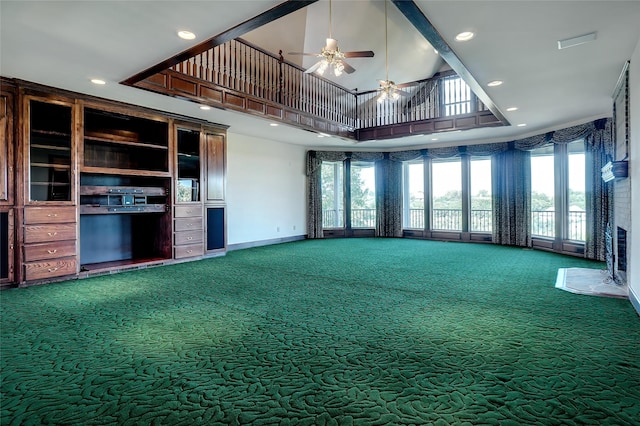 unfurnished living room with ceiling fan, carpet, and a high ceiling