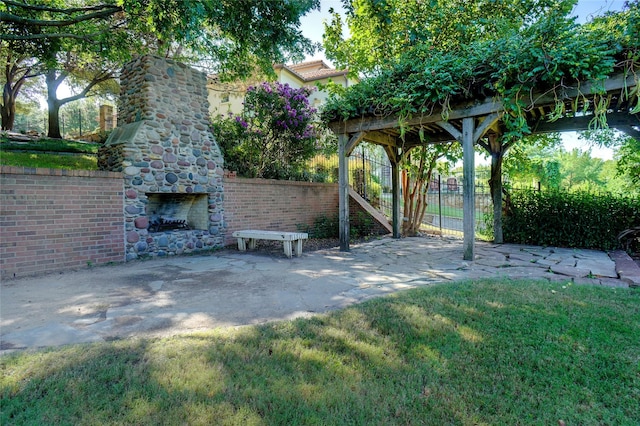 view of yard with a patio area and an outdoor stone fireplace