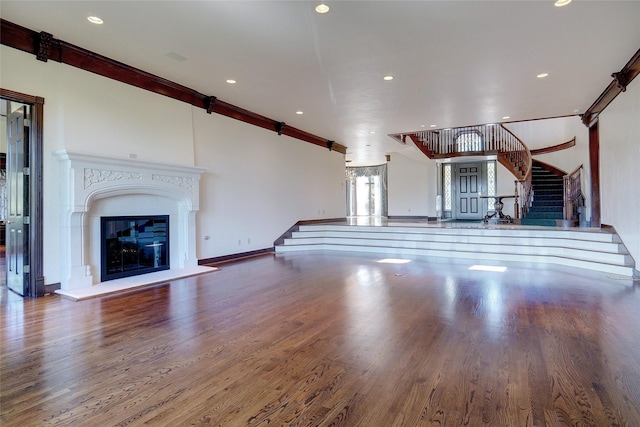 unfurnished living room with crown molding and wood-type flooring