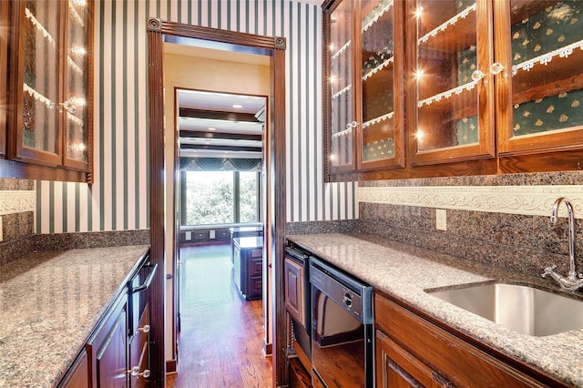 kitchen featuring dishwasher, light stone countertops, sink, and dark hardwood / wood-style flooring