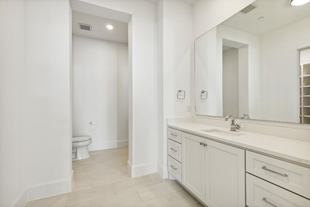 bathroom featuring toilet, large vanity, and tile flooring