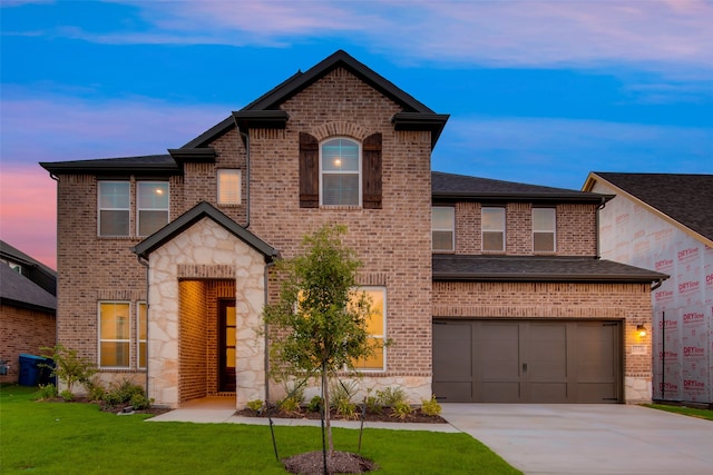 view of front of home with a garage and a yard