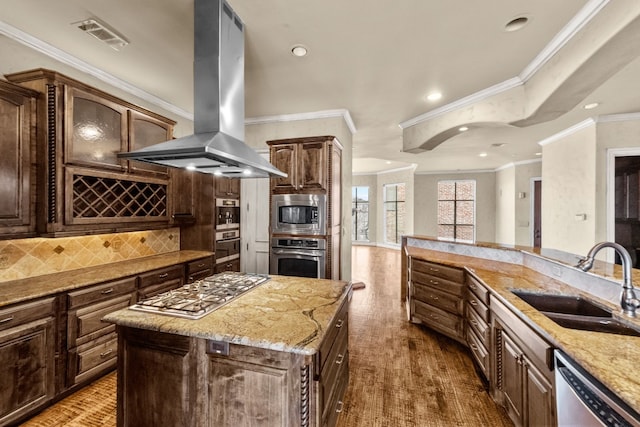 kitchen with stainless steel appliances, a center island, tasteful backsplash, island exhaust hood, and sink