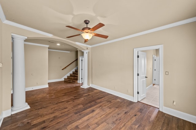 spare room featuring ornamental molding, ceiling fan, dark wood-type flooring, and ornate columns