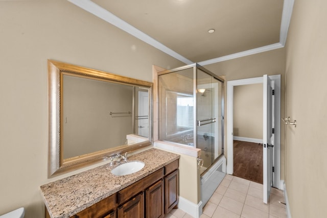 bathroom with tile flooring, oversized vanity, enclosed tub / shower combo, and ornamental molding