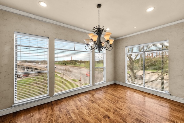 spare room featuring an inviting chandelier, a wealth of natural light, and light hardwood / wood-style flooring