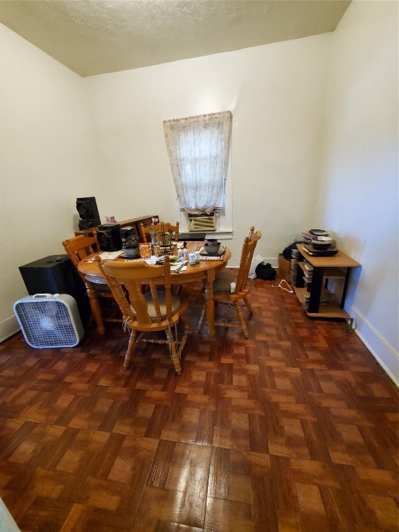 dining space featuring dark parquet floors and a textured ceiling