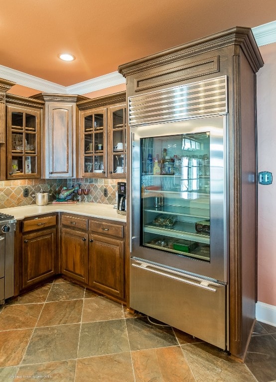 kitchen with tile floors, crown molding, beverage cooler, and tasteful backsplash