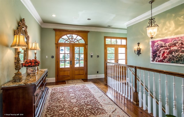 foyer entrance with plenty of natural light, dark hardwood / wood-style floors, crown molding, and french doors