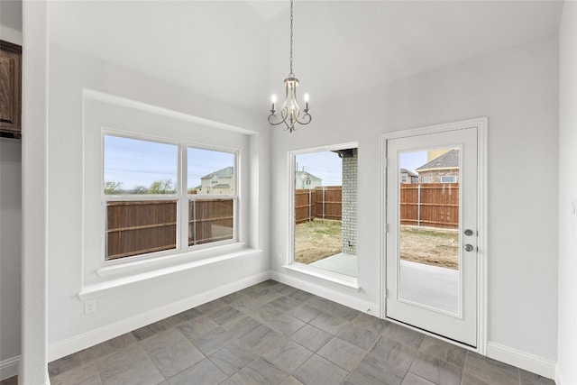 interior space featuring a notable chandelier, dark tile floors, and a wealth of natural light