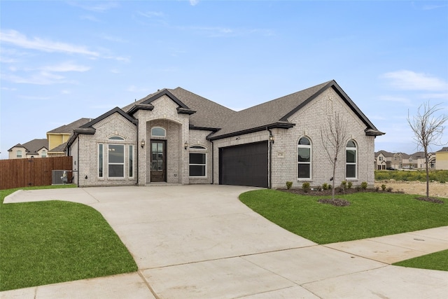 french country style house with a front lawn and a garage