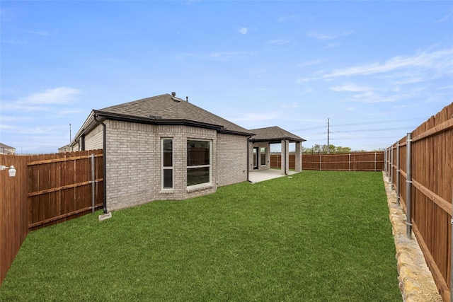 rear view of house featuring a lawn and a patio area