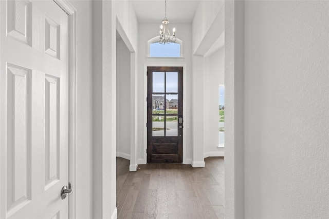 entrance foyer with a chandelier, a high ceiling, and light wood-type flooring