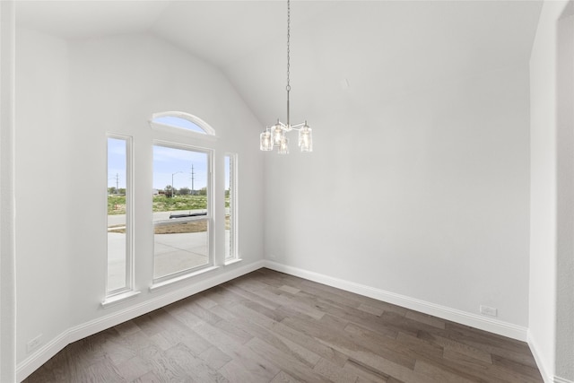 unfurnished room featuring dark hardwood / wood-style floors, vaulted ceiling, and a chandelier