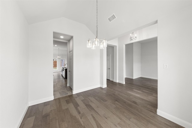 unfurnished room with lofted ceiling, a chandelier, and dark wood-type flooring