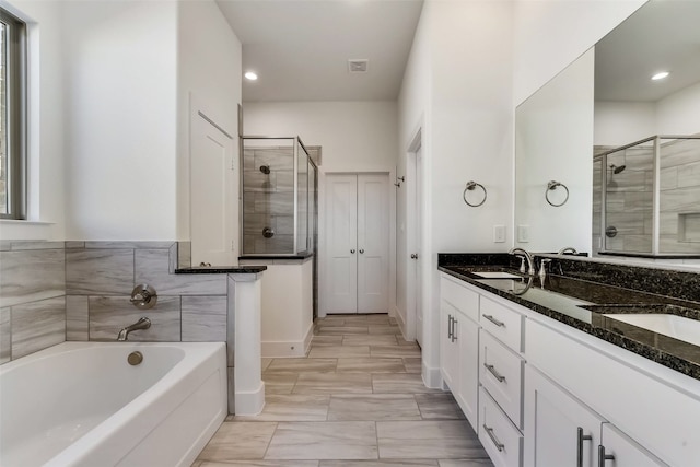 bathroom featuring plus walk in shower, vanity, and plenty of natural light