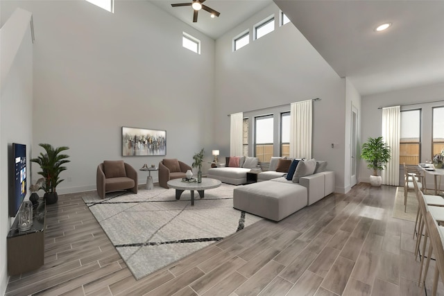 living room with a towering ceiling, a wealth of natural light, and ceiling fan