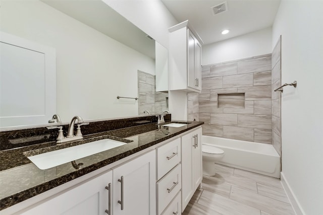 full bathroom with vanity, toilet, and tiled shower / bath combo