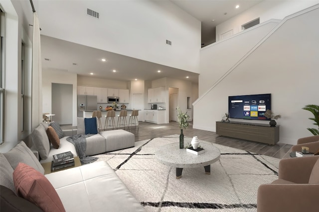 living room with wood-type flooring and a high ceiling