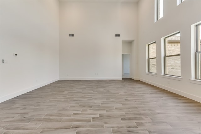 spare room with a high ceiling and a healthy amount of sunlight