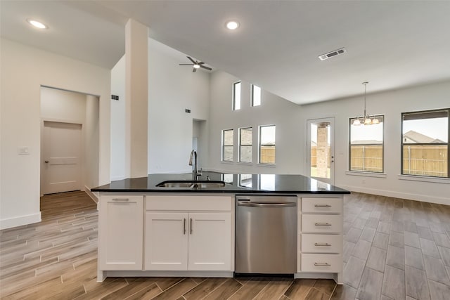 kitchen featuring dishwasher, white cabinets, sink, an island with sink, and decorative light fixtures