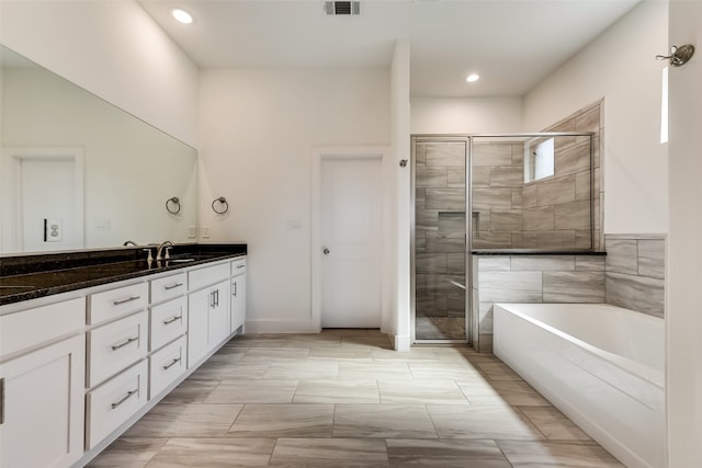 bathroom featuring vanity and independent shower and bath