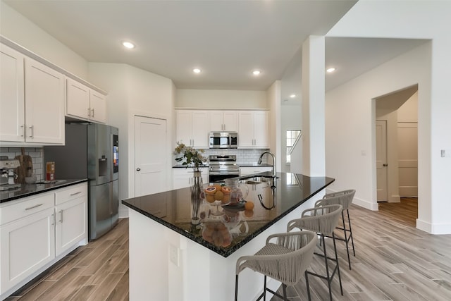 kitchen featuring white cabinetry, a center island with sink, and appliances with stainless steel finishes