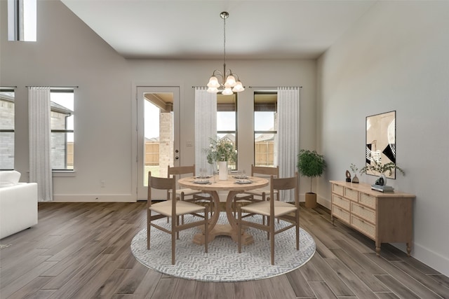 dining space featuring dark hardwood / wood-style floors and an inviting chandelier