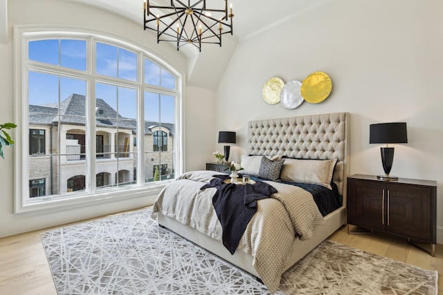 bedroom with a notable chandelier and light wood-type flooring