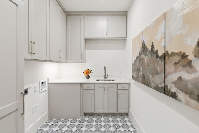 kitchen featuring gray cabinets, light tile floors, and sink