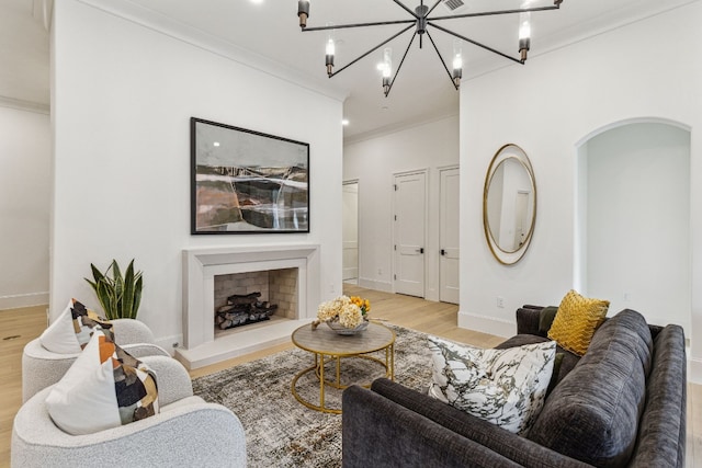 living room with ornamental molding, light hardwood / wood-style floors, and a notable chandelier