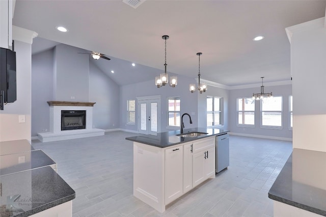 kitchen with ceiling fan with notable chandelier, white cabinetry, a kitchen island with sink, and plenty of natural light