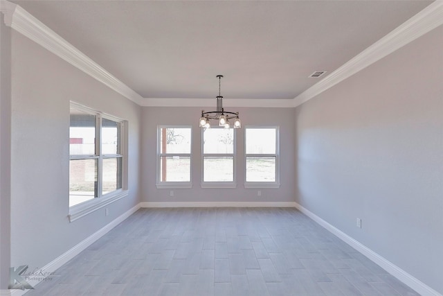 empty room featuring crown molding and a chandelier