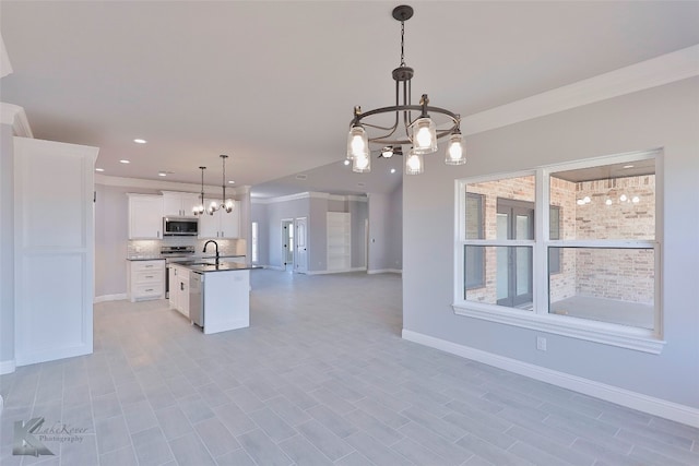 kitchen with sink, an island with sink, white cabinets, backsplash, and decorative light fixtures