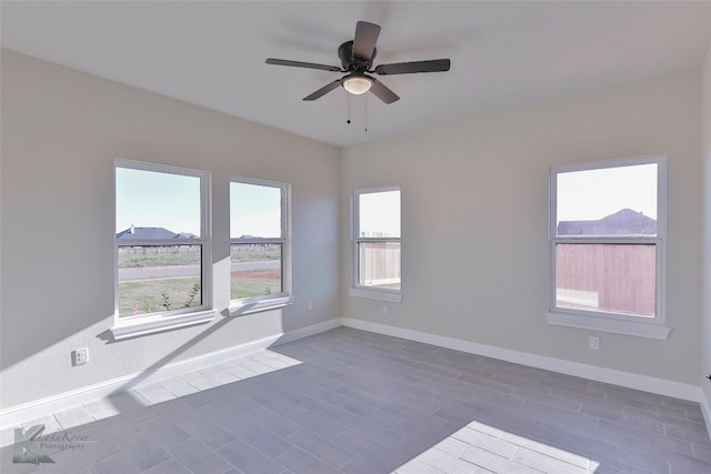 unfurnished room featuring ceiling fan, dark hardwood / wood-style flooring, and a healthy amount of sunlight