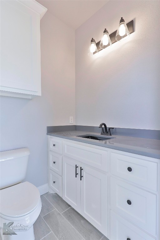 bathroom with vanity, tile patterned flooring, and toilet