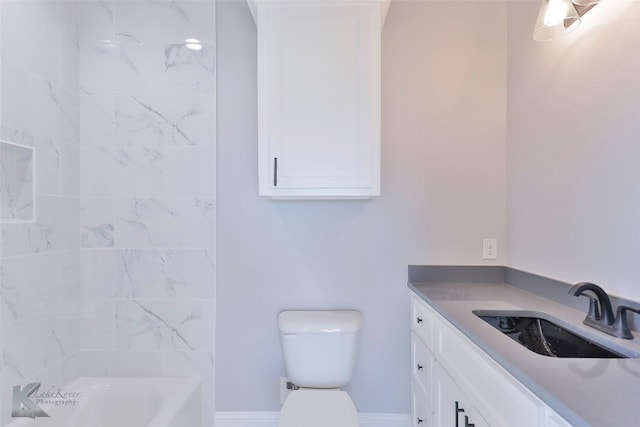 full bathroom with tiled shower / bath, vanity, and toilet