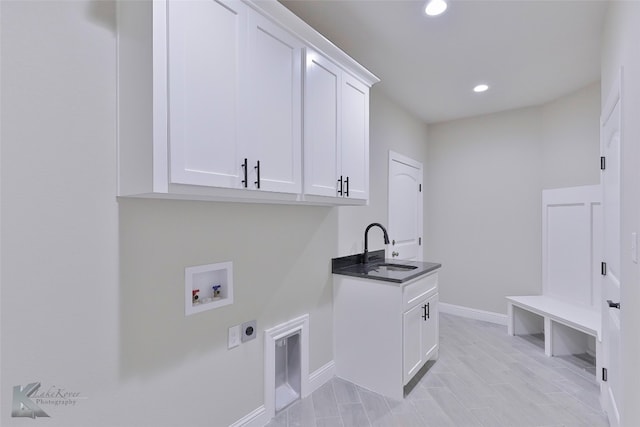 washroom featuring washer hookup, cabinets, sink, and hookup for an electric dryer