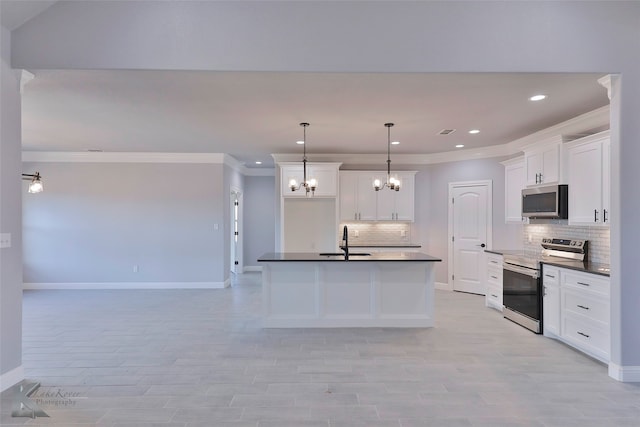 kitchen with white cabinets, a kitchen island with sink, stainless steel appliances, and pendant lighting