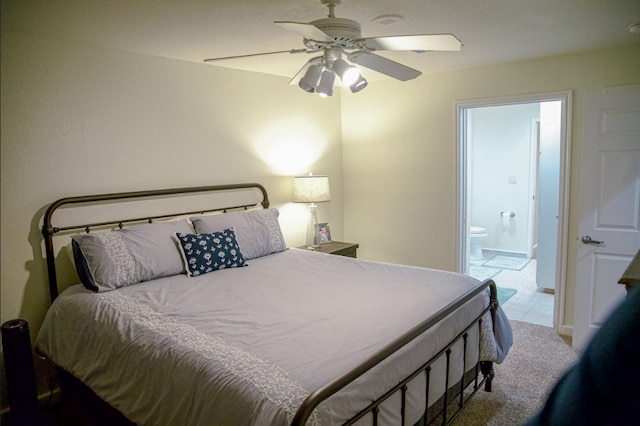 bedroom with ceiling fan, ensuite bathroom, and light tile floors