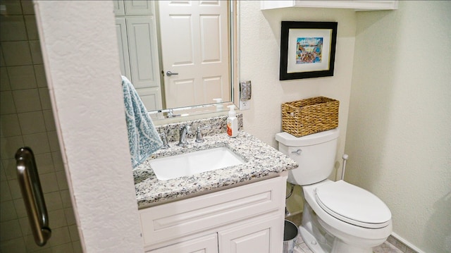 bathroom featuring tile floors, toilet, and vanity